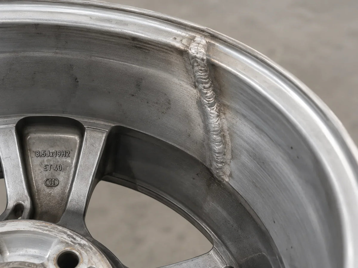Binnenzijde van een gebruikte velg met zichtbare lasreparatie